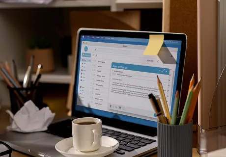 Laptop on a desk showing an email inbox